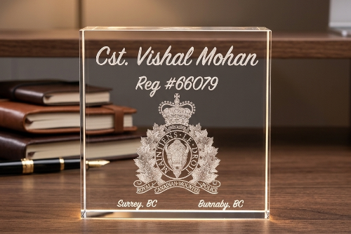 Clear acrylic block with engraved text and logo on a desk