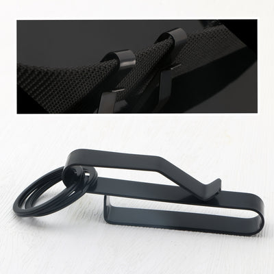 Black metal clip with ring on white background, inset of clip on textured surface.