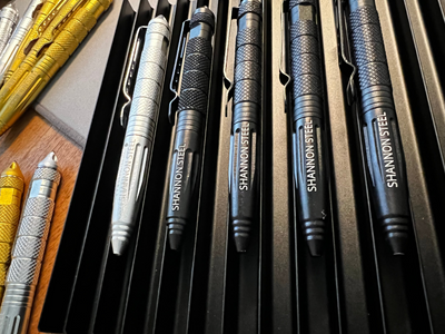 Collection of Shannon Steel pens on a wooden surface