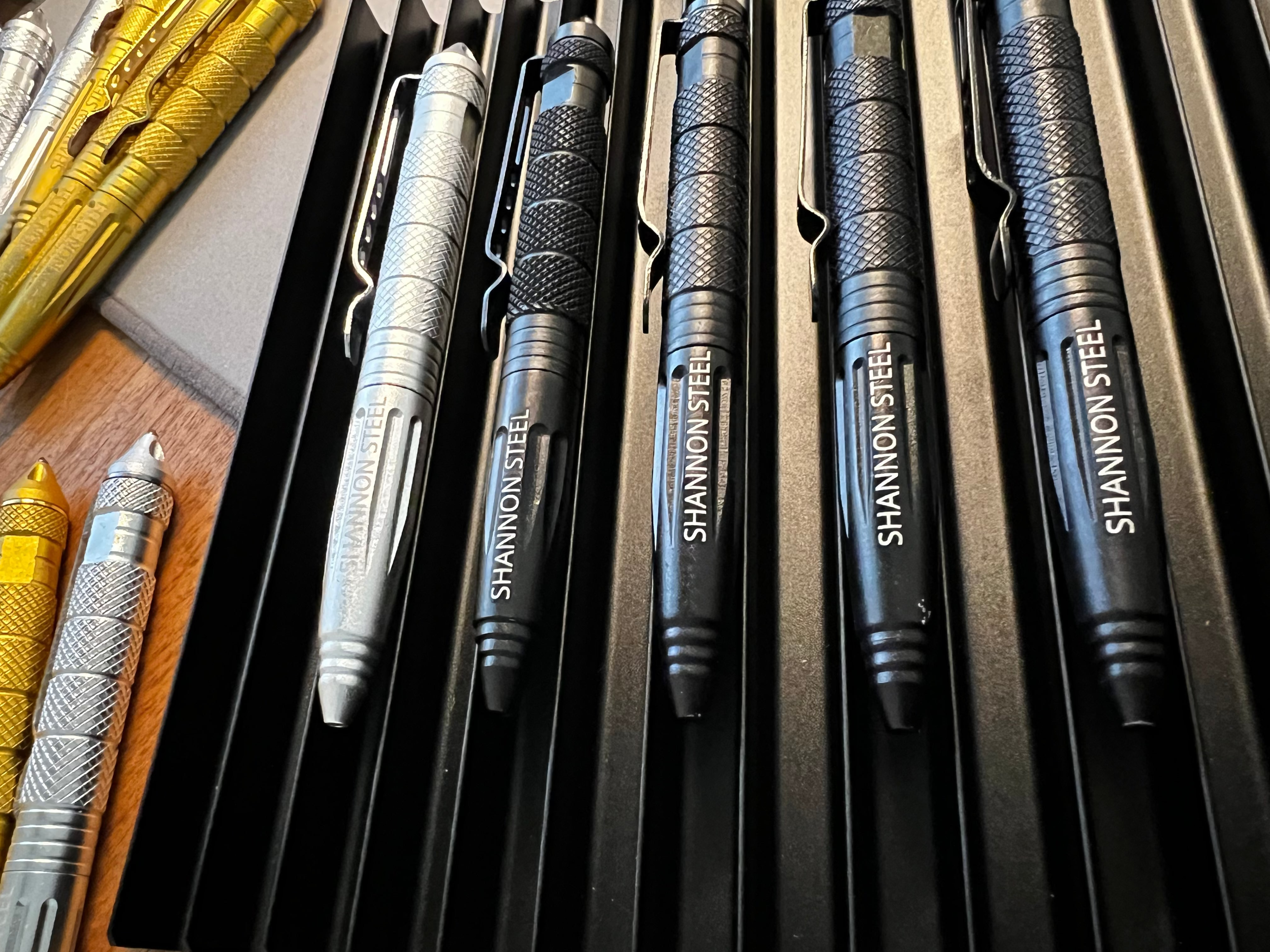 Collection of Shannon Steel pens on a wooden surface