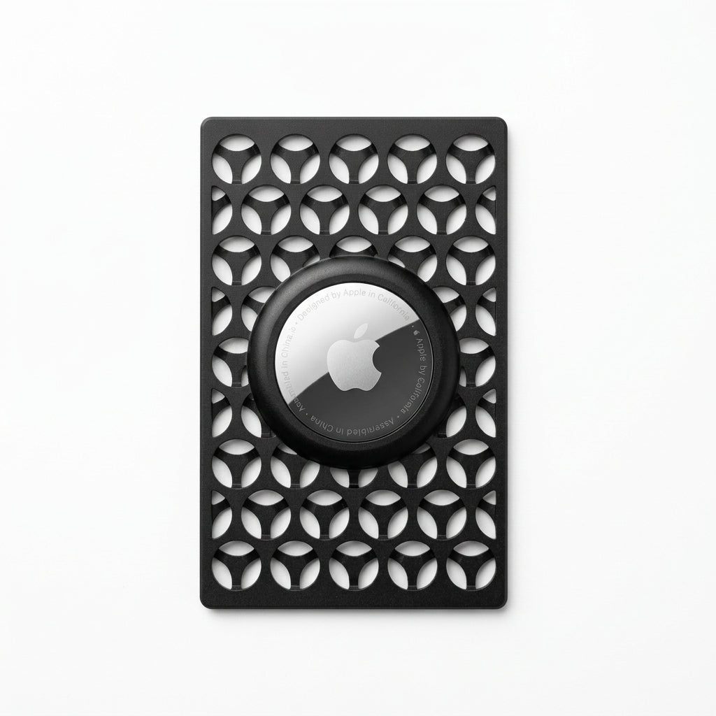 A black protective airtag case with a geometric cutout pattern and a circular magnetic ring, shown on a plain white background.