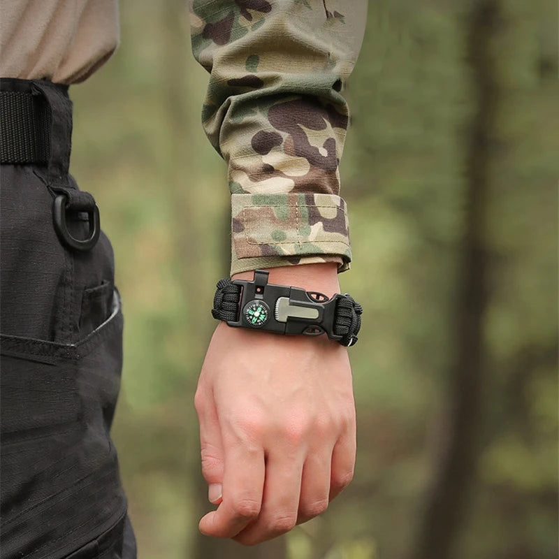 Person wearing a tactical wrist device with a forest background