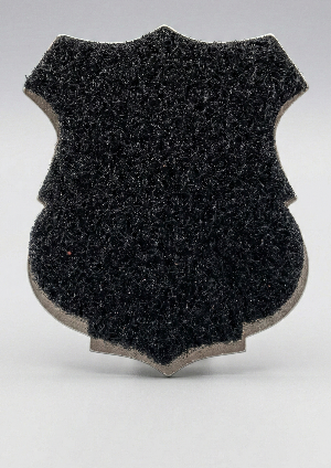 Black textured shield-shaped object on a gray background